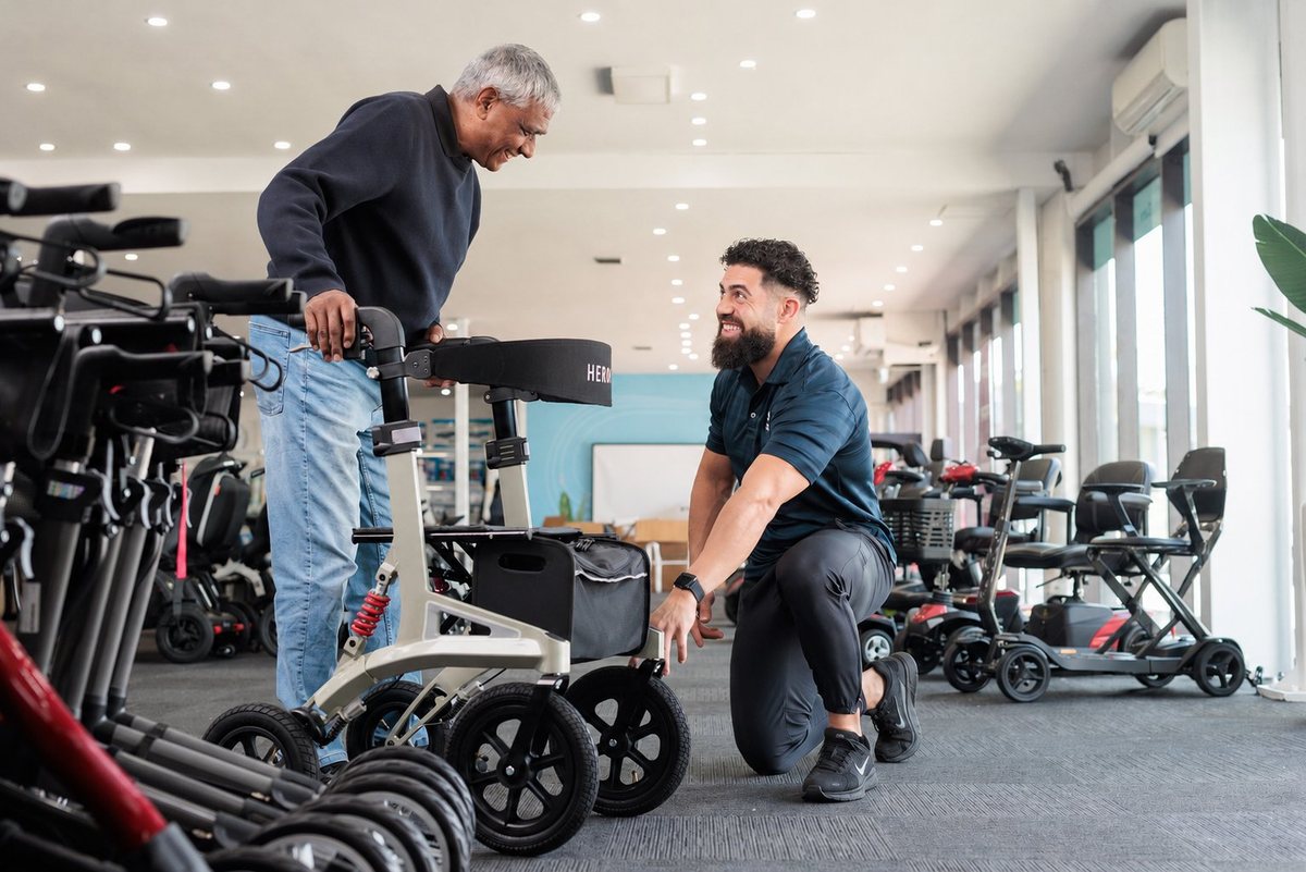 An ILS specialist helping a customer adjust a rollator in a showroom